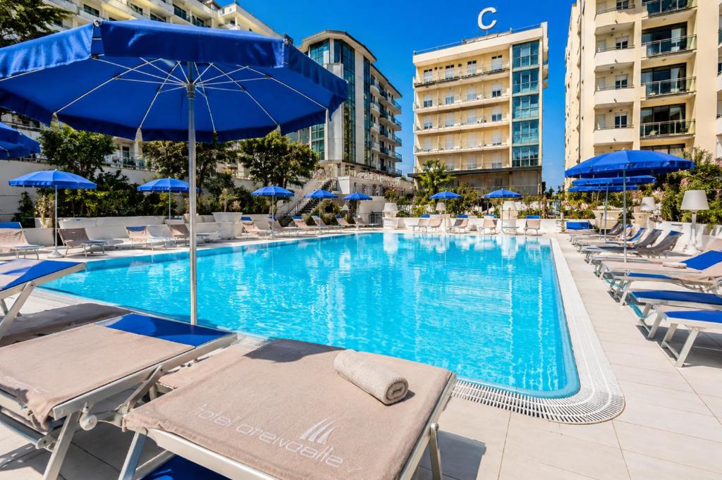 a swimming pool with lounge chairs and umbrellas at Hotel Caravelle - Nuova Gestione 2026 in Cattolica