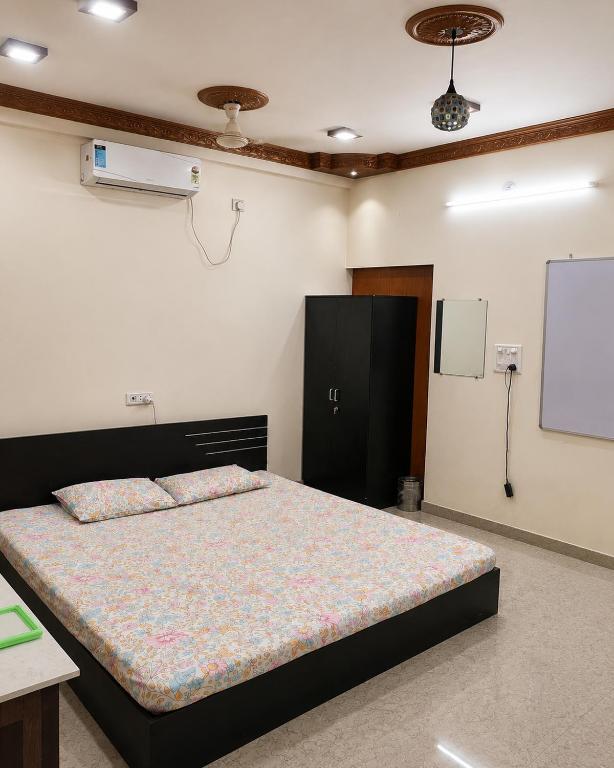 a bedroom with a bed and a projection screen at Maple studio in Patna