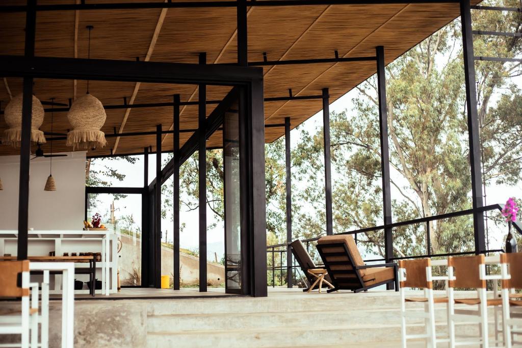 a pavilion with chairs and tables and windows at Kibuye House in Kibuye