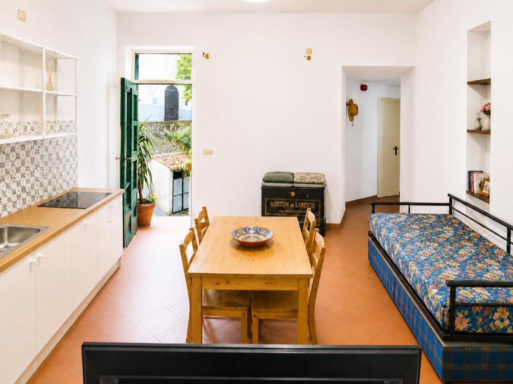 a kitchen and dining room with a table and a bed at Bella Maratea in Maratea