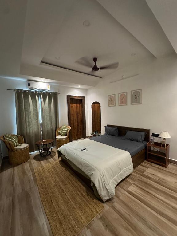 a bedroom with a bed and a couch and a table at Asoe living in Jorhat