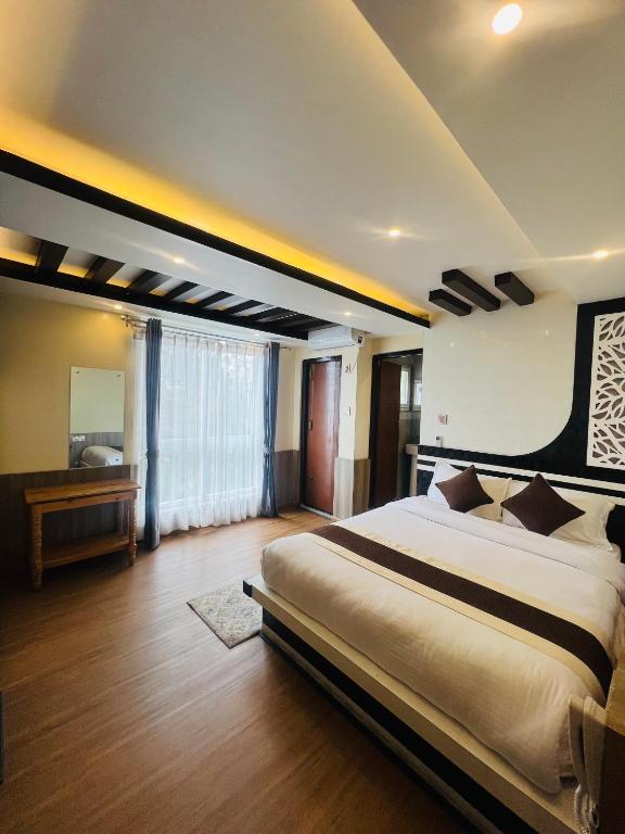 a large bedroom with a large bed and a television at Pine Tree Resort in Nagarkot