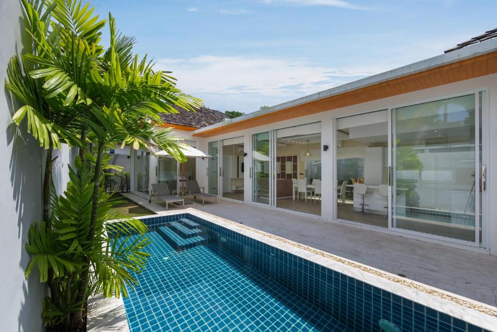 a swimming pool in front of a villa at 5 Minutes to Naiharn Beach, Private, Quiet and Cozy in Nai Harn Beach