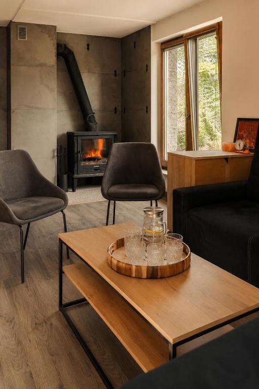 a living room with two chairs and a coffee table at Agroturystyka Monte Luna - Domki in Czarnów