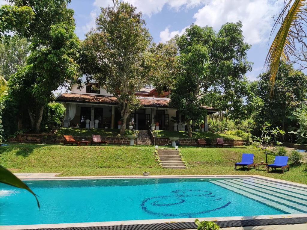 a villa with a swimming pool in front of a house at Villa Lyvie ayurvedic hotel in Tangalle
