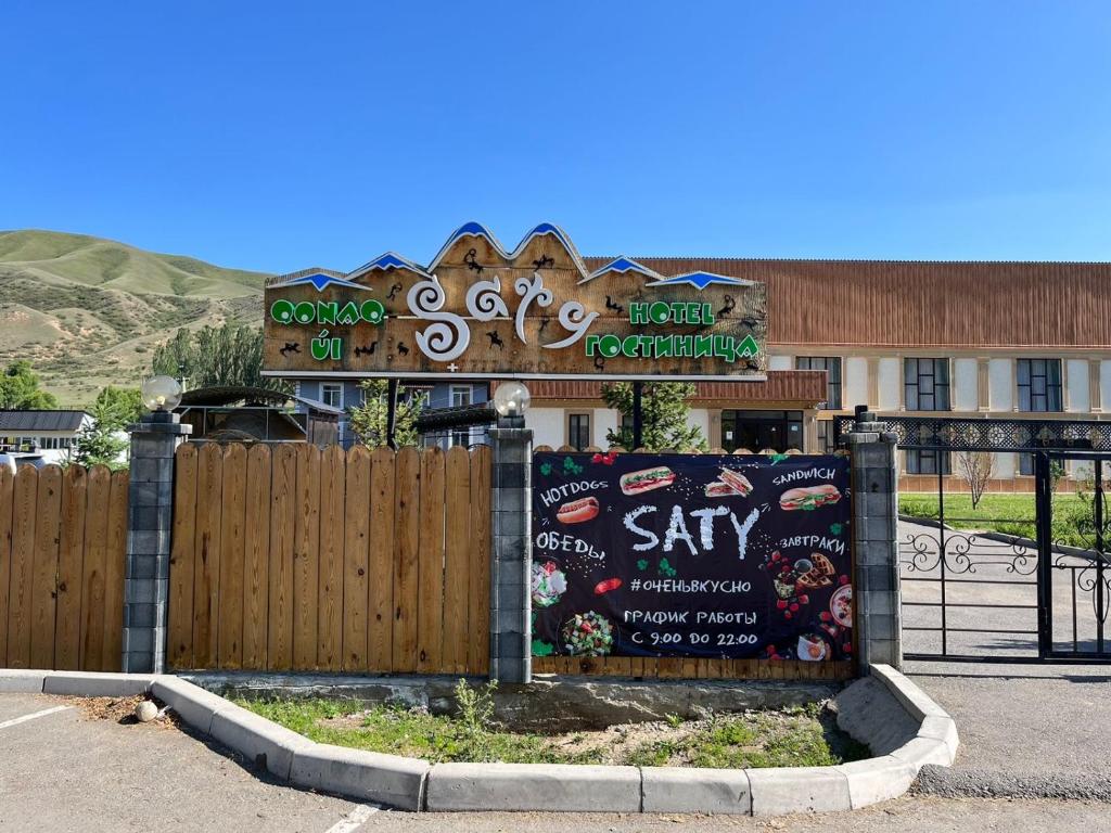 a sign in front of a building with a fence at Saty Guest House in Saty
