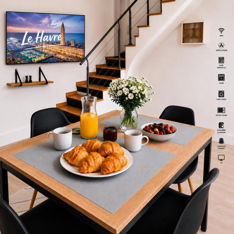 a table with a plate of croissants and fruit at Duplex 4 Personnes 5 Minutes a pied du petit port et 10 Minutes de la plage in Le Havre