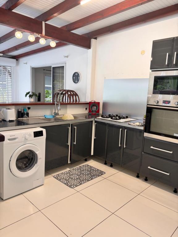 a kitchen with a washing machine and a washer at Co and co habitation in Lamentin