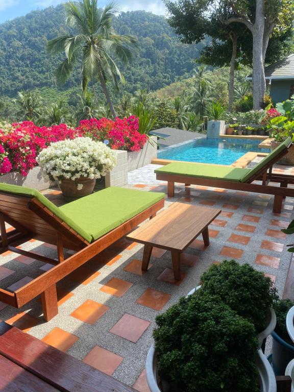 a patio with two benches and a swimming pool at keio place in Thong Nai Pan Yai
