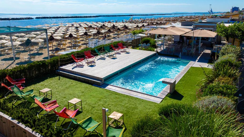 an overhead view of a pool with chairs and a beach at Hotel Savini in Bellaria-Igea Marina
