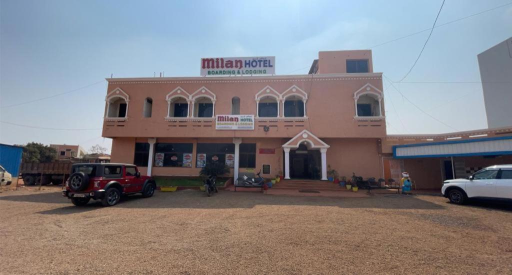 a building with a car parked in front of it at Milan Hotel in Zahirābād