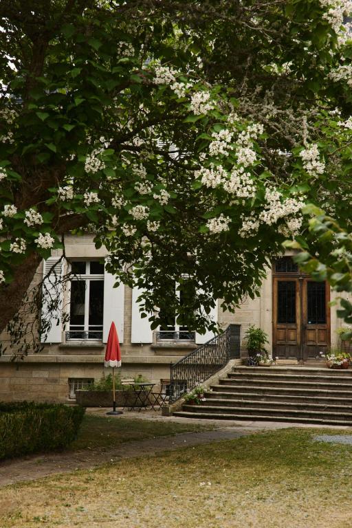 a house with stairs and a tree with white flowers at Chateau Gioux in Saint-Pierre-Bellevue