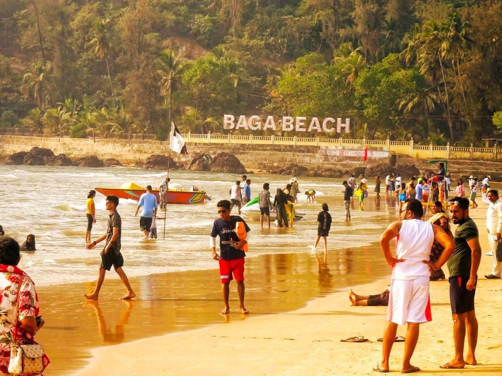 a group of people standing on a beach at Baga Ocean Way in Baga