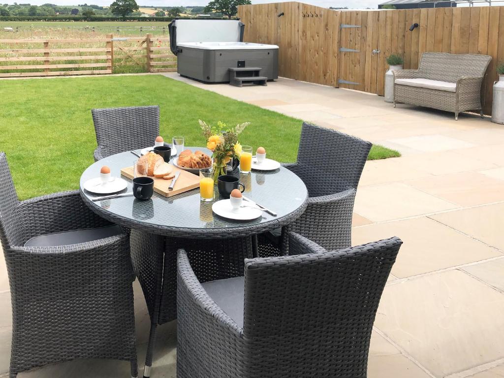 a table and chairs on a patio with a grill at The Old Dairy - Uk31253 in Middleton