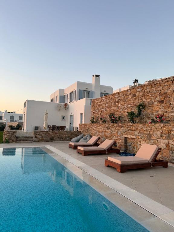 a swimming pool with lounge chairs next to a building at Galazio in Naxos Chora