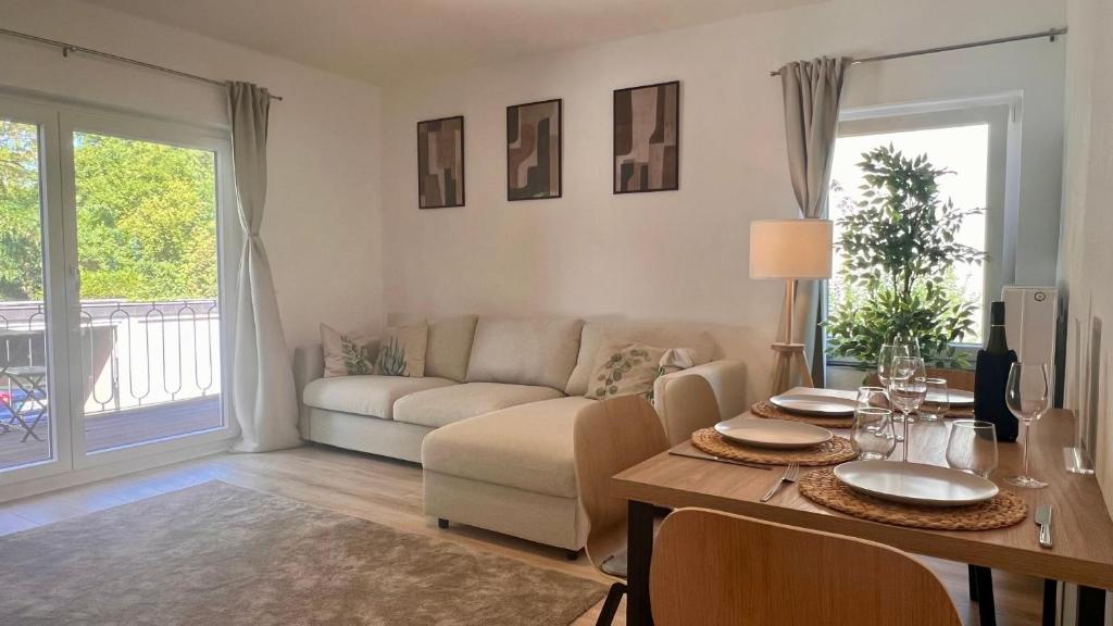 a living room with a table and a couch at Stilvolles Apartment im Siebengebirge in Königswinter