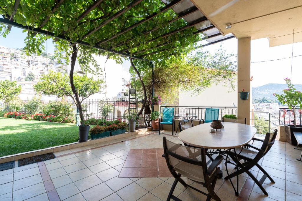 a patio with a table and chairs on a balcony at Με συμπάθεια-With sympathy - private parking in Kavála