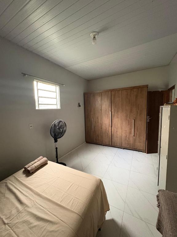 a bedroom with a bed and a window and a fan at Casa Completa no Centro de Soure com Wi fi e Garagem in Soure