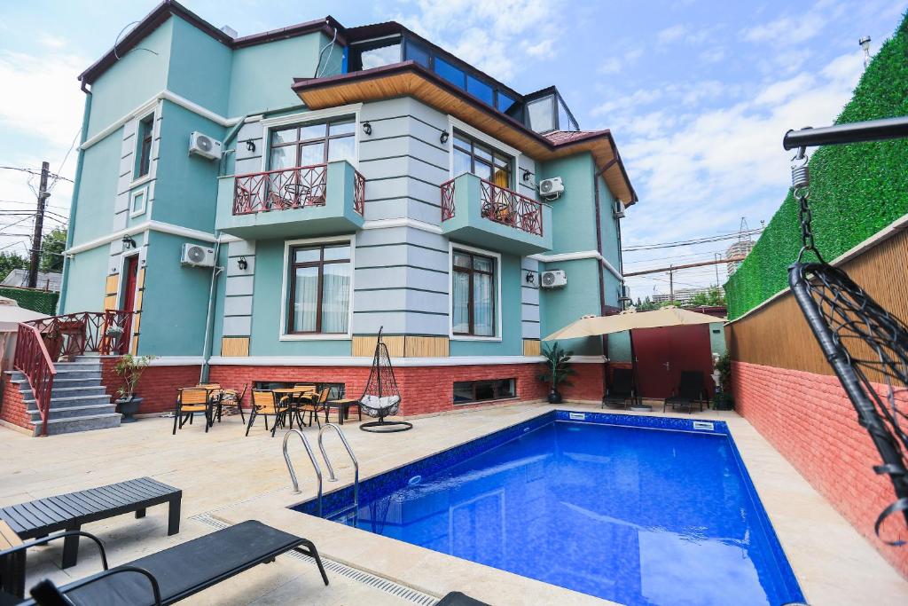 a house with a swimming pool in front of a house at Hotel Boutique Adam in Tbilisi City