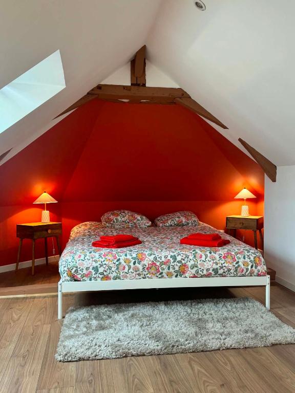 a bedroom with a bed with a red wall at Lumières de Tuffeau in Château-du-Loir