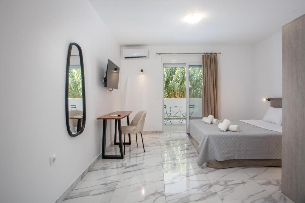 a bedroom with a bed and a table and a mirror at Dorians - Faliraki in Faliraki