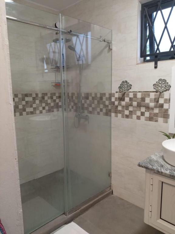 a glass shower in a bathroom with a sink at L'instant Varangue in Albion