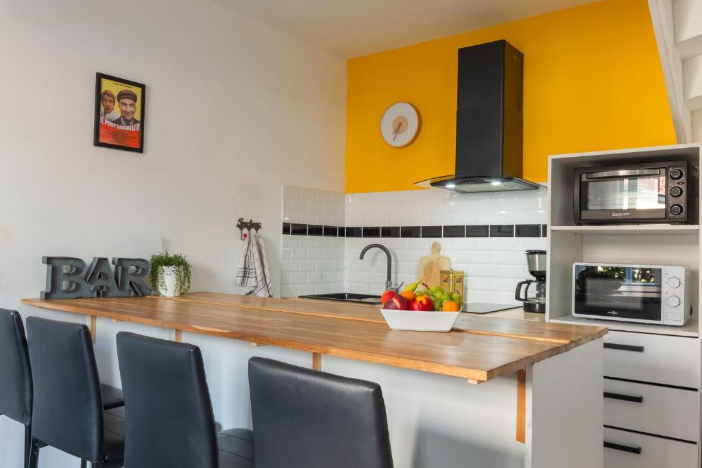 a kitchen with a counter with a bowl of fruit on it at Le petit baigneur, 300m de la mer et centre ville in Étretat