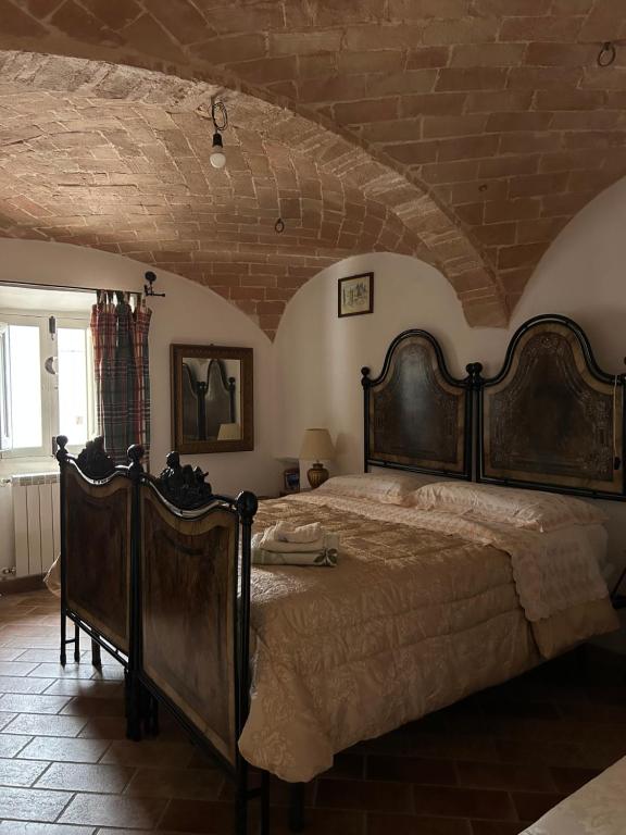 a bedroom with a large bed and a brick wall at Nido Stellato in Calascio