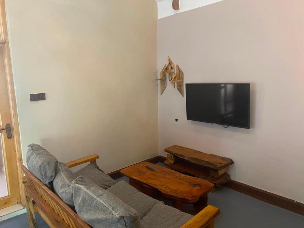 a living room with a couch and a flat screen tv at Osinoni Cottages in Isiolo