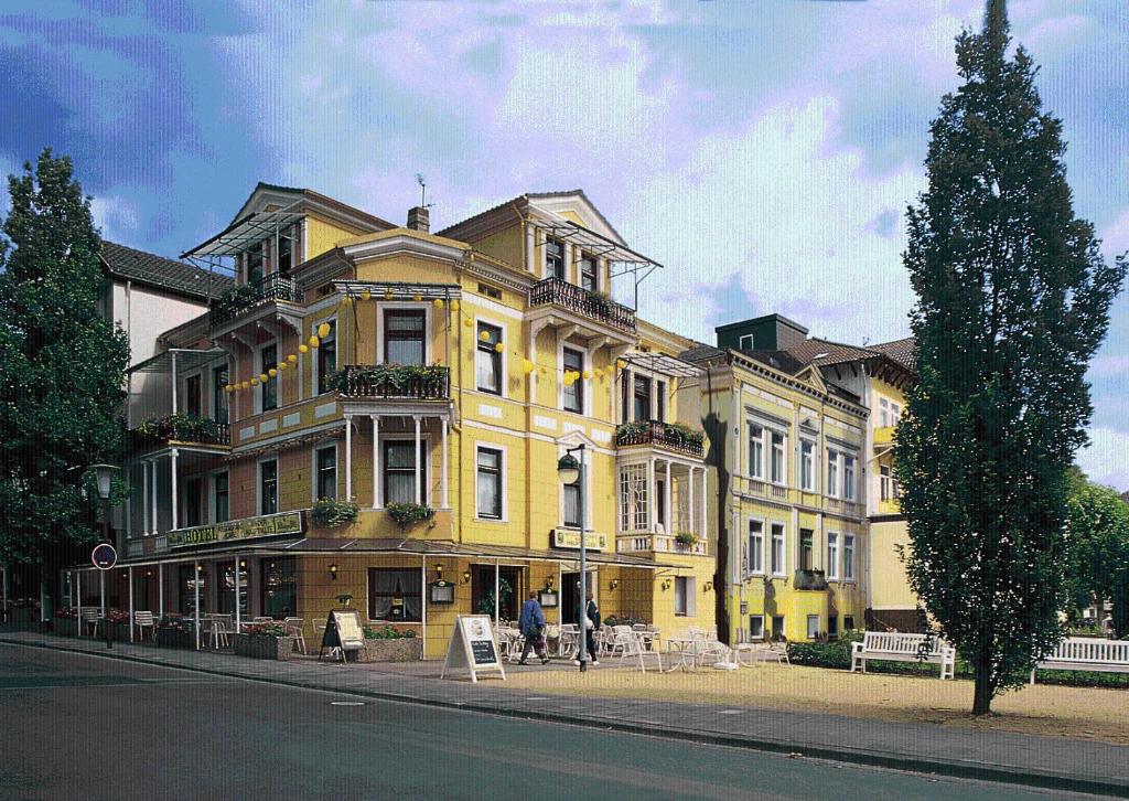 ein großes gelbes Gebäude an der Straßenseite in der Unterkunft Hotel an der Hauptallee in Bad Pyrmont