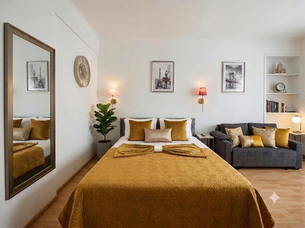 a bedroom with a bed and a mirror and a couch at Studio Bulle de Rêve à deux pas du Port in Nice
