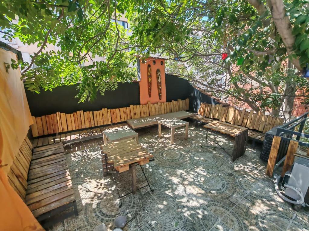 a backyard with a table and benches and a fence at Shantihome in İzmir