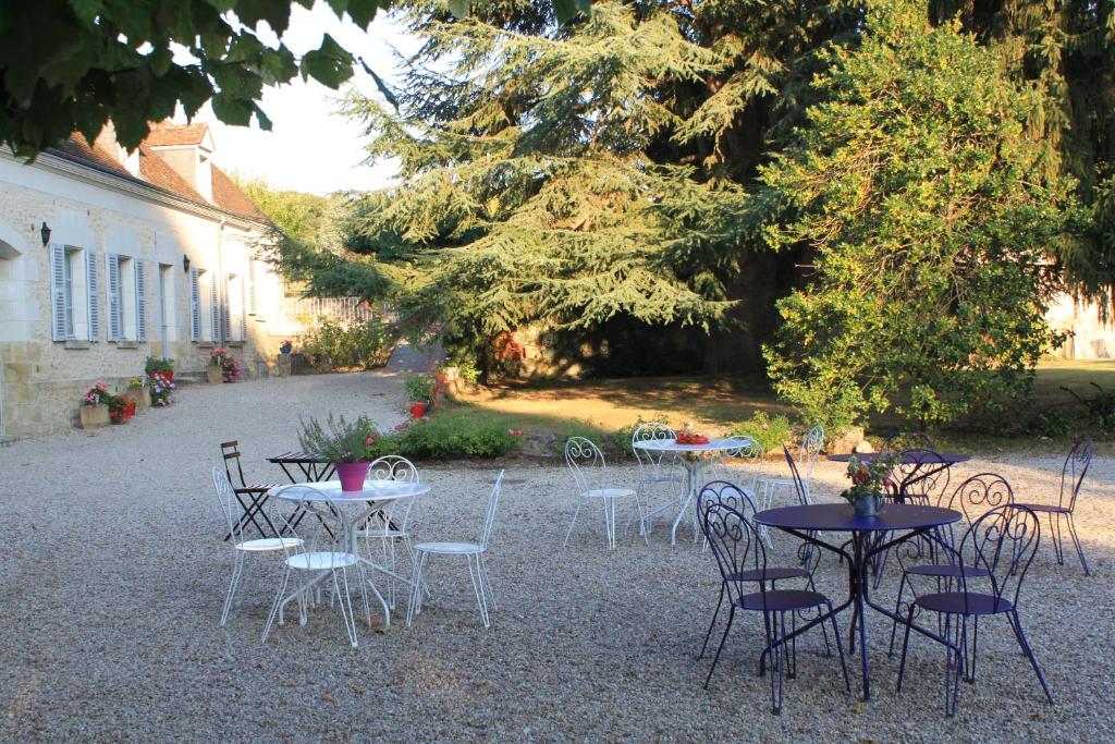 un grupo de mesas y sillas en un patio en Bella Simonetta en Francueil