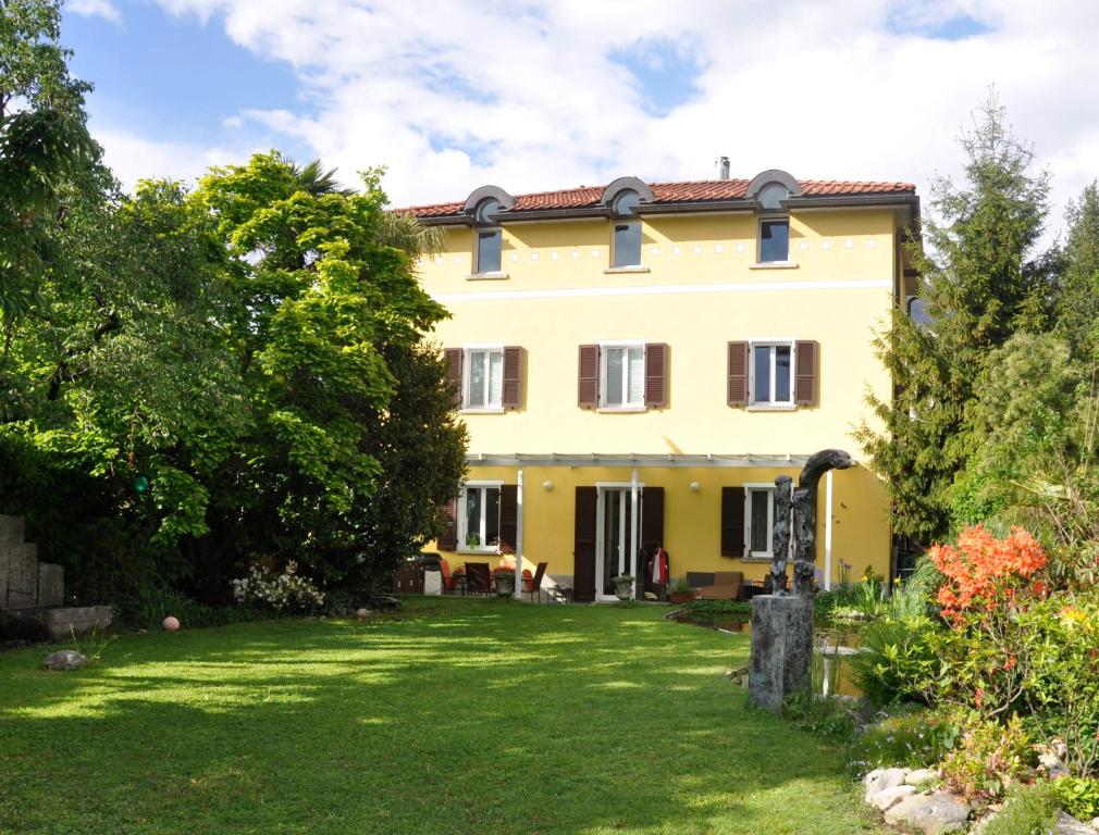 ein großes gelbes Haus mit einem Hof in der Unterkunft Villa del Gusto in Bellinzona