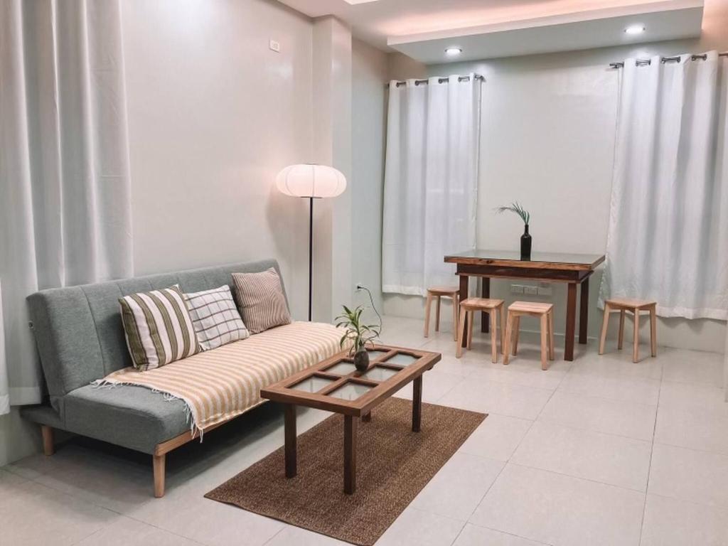 a living room with a couch and a table at 1BR Apartment Beach Getaway Perfect for Couples in Bangcusay