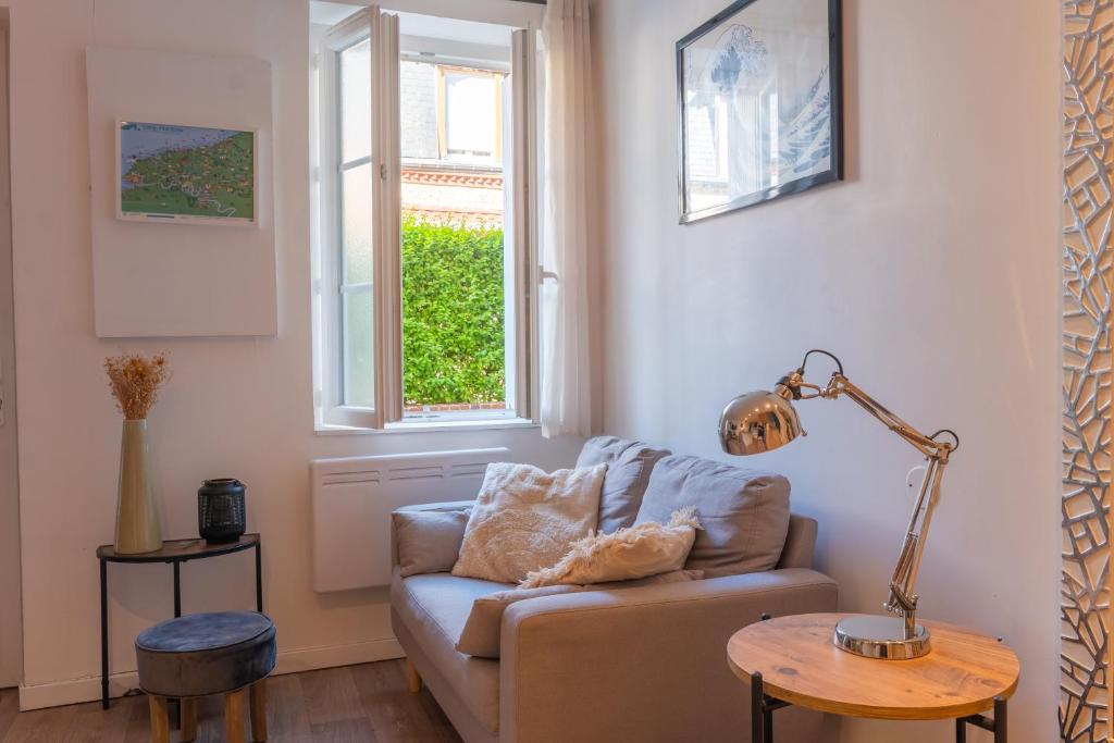 a living room with a couch and a window at Le grand bleu, 300m de la mer et centre ville in Étretat