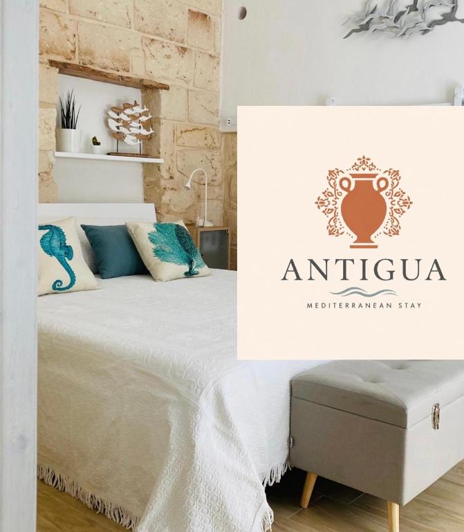 a bedroom with an antigua sign and a bed at Antigua in Monopoli