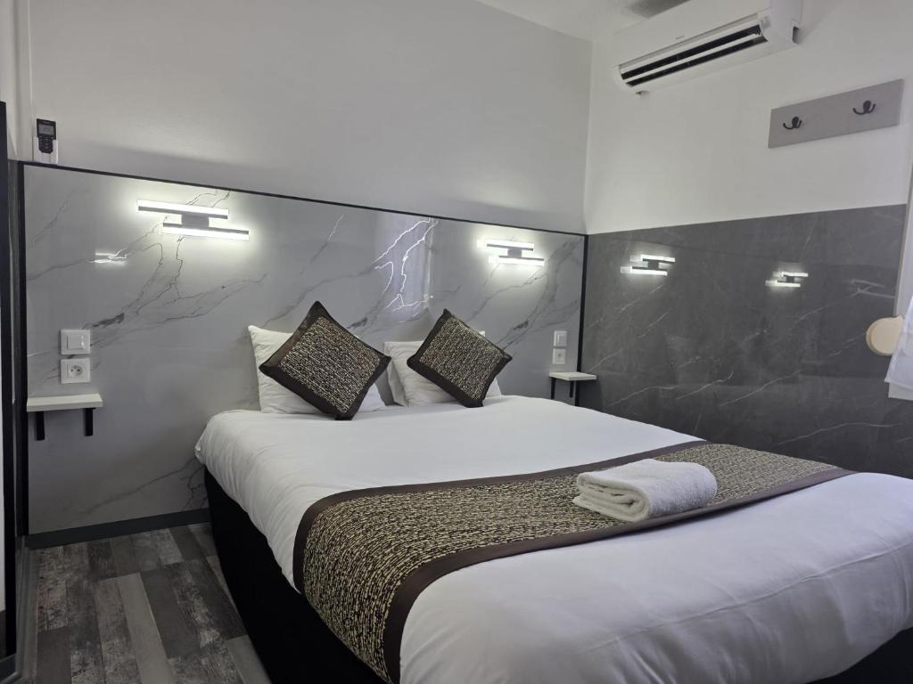a bedroom with a large bed with white sheets and pillows at Fasthotel Tours Nord in Parçay-Meslay