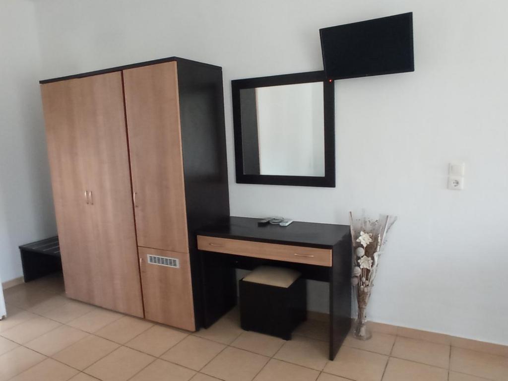 a bathroom with a vanity and a mirror and a cabinet at Blue Bay Club in Vrachonisída Omprélla