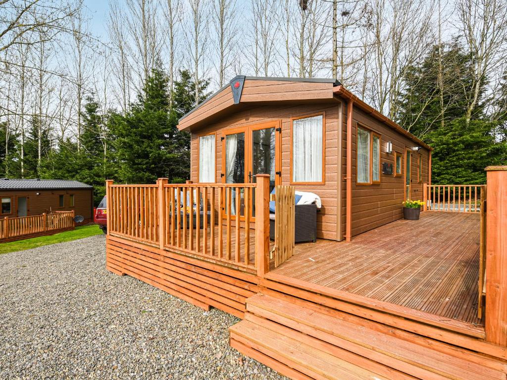 a large wooden cabin with a deck at Avon Lodge in Hyssington