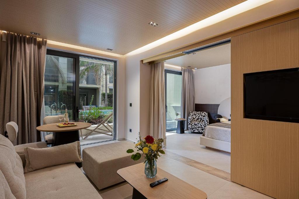 a living room with a couch and a tv in a room at Pearl Beach in Rethymno
