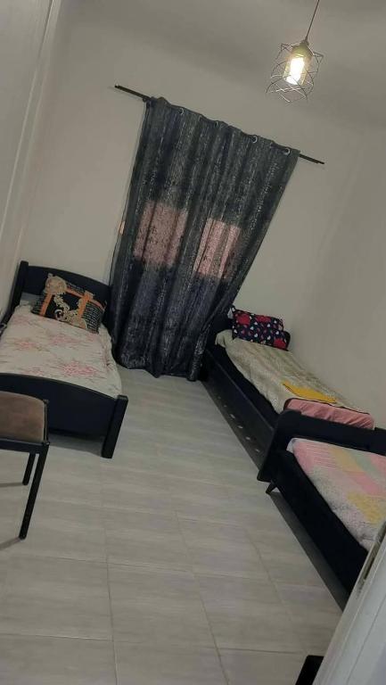 two beds in a room with a window at Jijel in Jijel