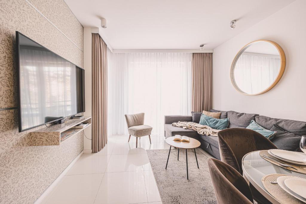 a living room with a couch and a table at Maritimo Apartament przy Porcie by 2HomeRent in Kołobrzeg