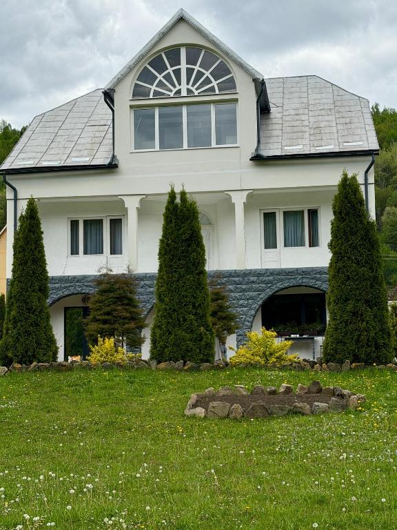 a large white house with a gambrel at Садиба "Віталія" in Volovets