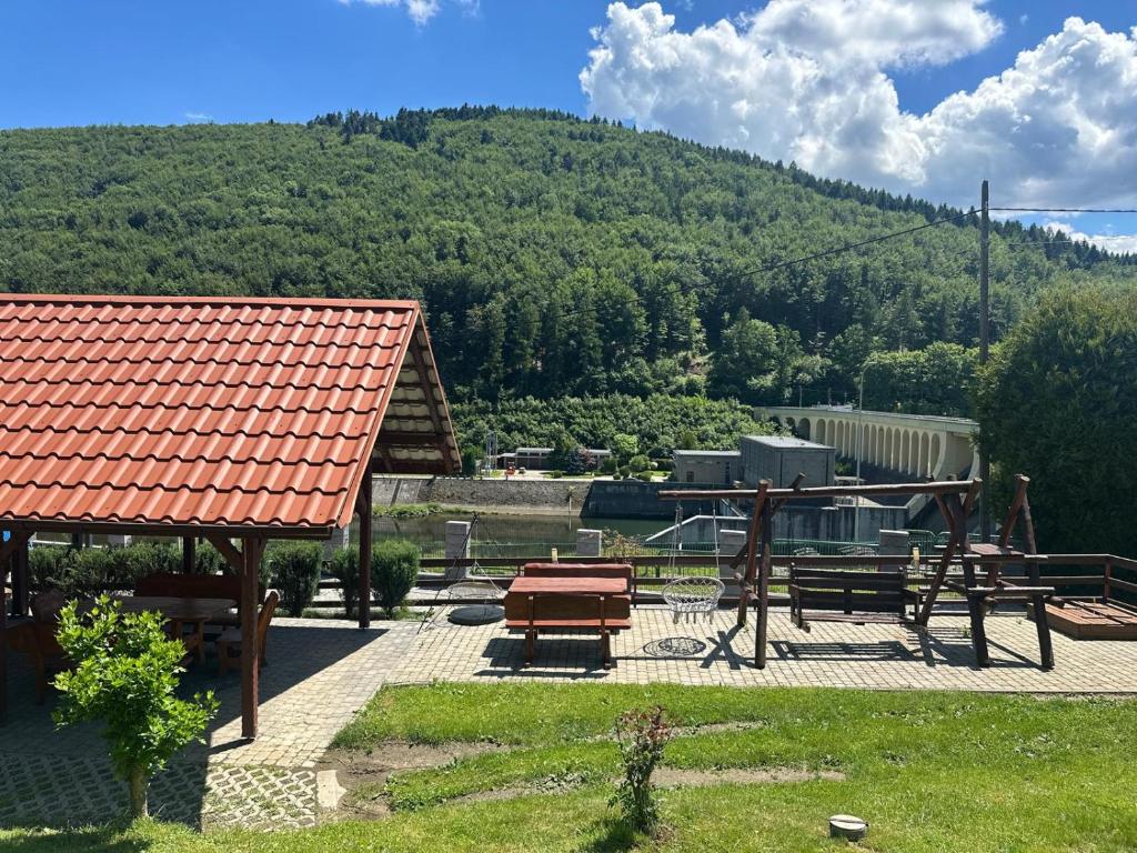 a picnic shelter with benches and a mountain at Noclegi nad Zaporą in Międzybrodzie Bialskie