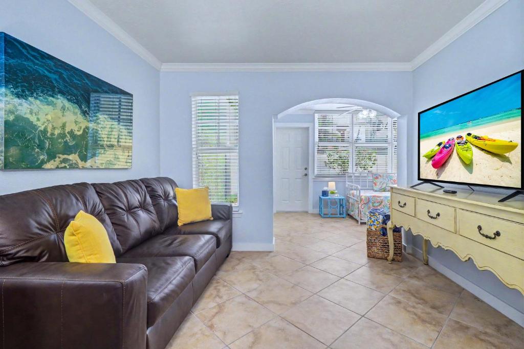 a living room with a couch and a large screen tv at Barefoot Beach Resort F104 in Clearwater Beach