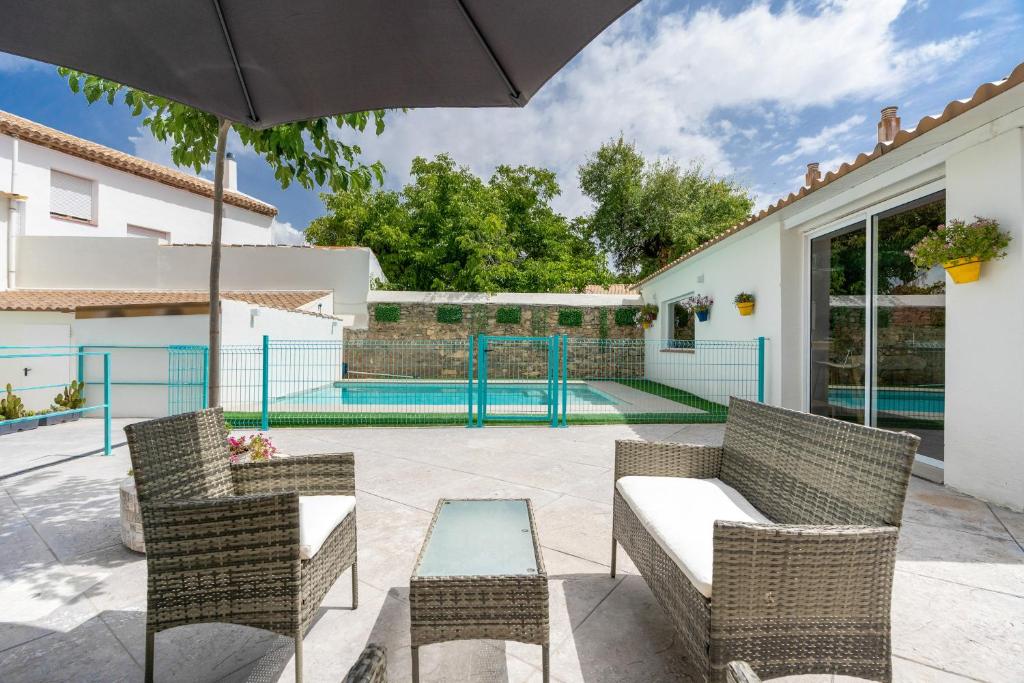 a patio with a table and chairs and an umbrella at Raízes 22 - Apartamento 6 in Puebla de Don Fadrique