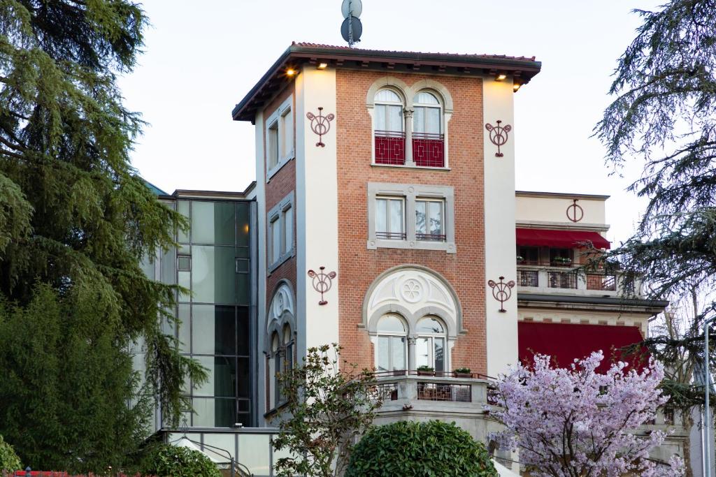 a tall brick building with windows and trees at VILLA UGO b & b in Salsomaggiore Terme