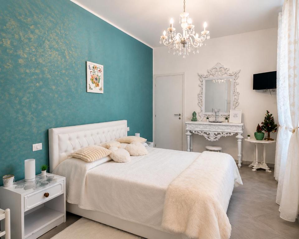 a bedroom with a white bed and a blue wall at B&B Jasmine Park Ormea in Ormea
