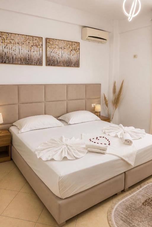 a bedroom with a large bed with white sheets at Guesthouse Zisi in Gjirokastër